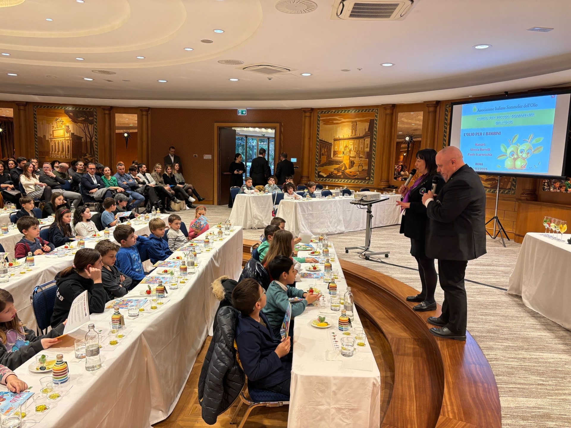 Panoramica della sala durante la lezione dedicata ai più piccoli “L'Olio dei Bambini” guidata dai docenti Alessia Borrelli e Paolo Scarnecchia Panoramica della sala durante la lezione dedicata ai più piccoli “L'Olio dei Bambini” guidata dai docenti Alessia Borrelli e Paolo Scarnecchia